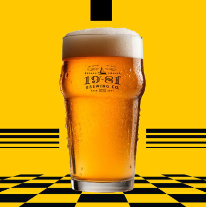 1981 Brewing Co pint of beer on yellow checkered background.