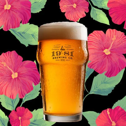 1981 Brewing Co. Sorrel hibiscus beer in glass on floral background. Tropical, refreshing.