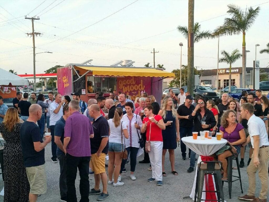 A group of people enjoying 19-81 beers outdoors at the 19-81 Brewing Co. taproom in Grand Cayman