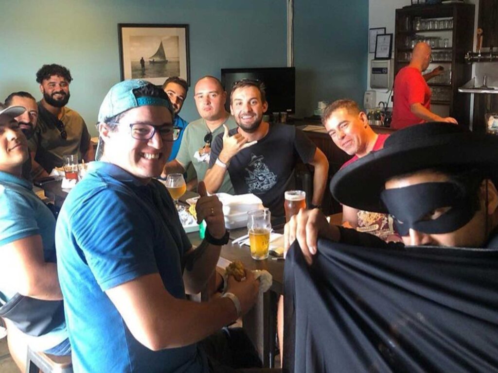 A group of guys laughing and enjoying 19-81 Cayman beers at the 19-81 Brewing Co. taproom