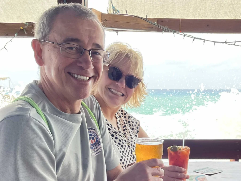 Couple enjoys beachfront drinks with ocean views.